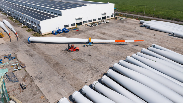 Aerial shot of a wind turbine manufacturing facility with multiple turbines stacked up outdoors