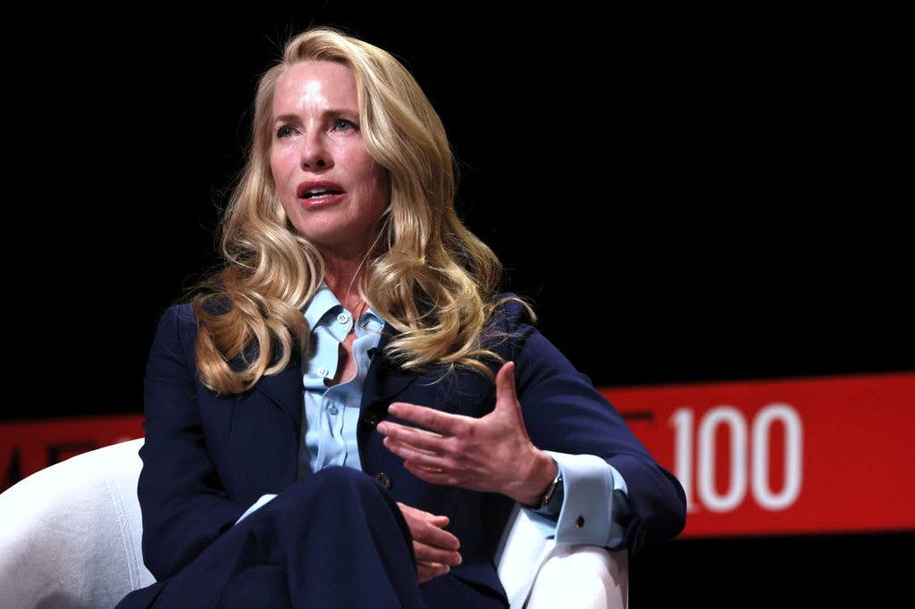 Laurene Powell Jobs wearing blue button down shirt and navy blazer