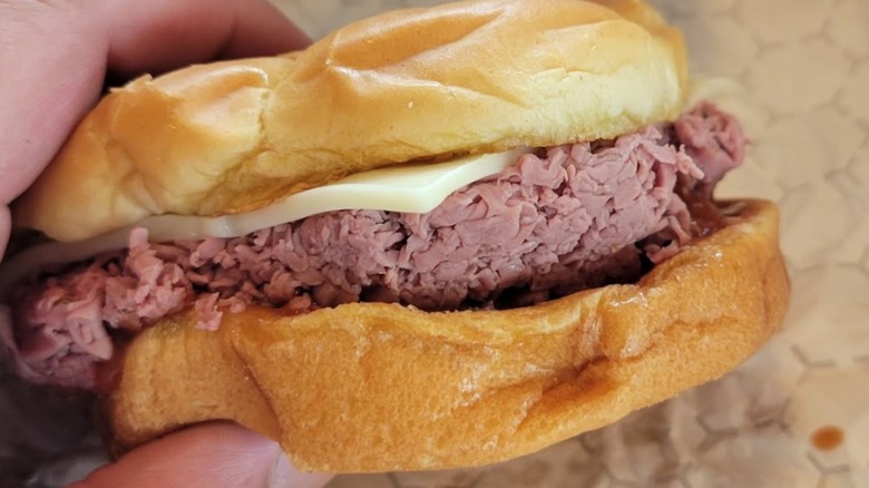 Hand holding a Roast Beef Sandwich from Miller's Famous Sandwiches