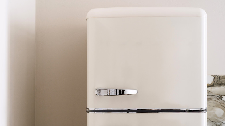 A retro white refrigerator against a white wall