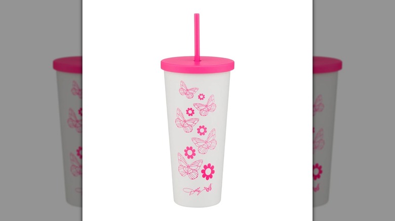 White drink tumbler with pink butterfly and floral decor with a pink lid and straw
