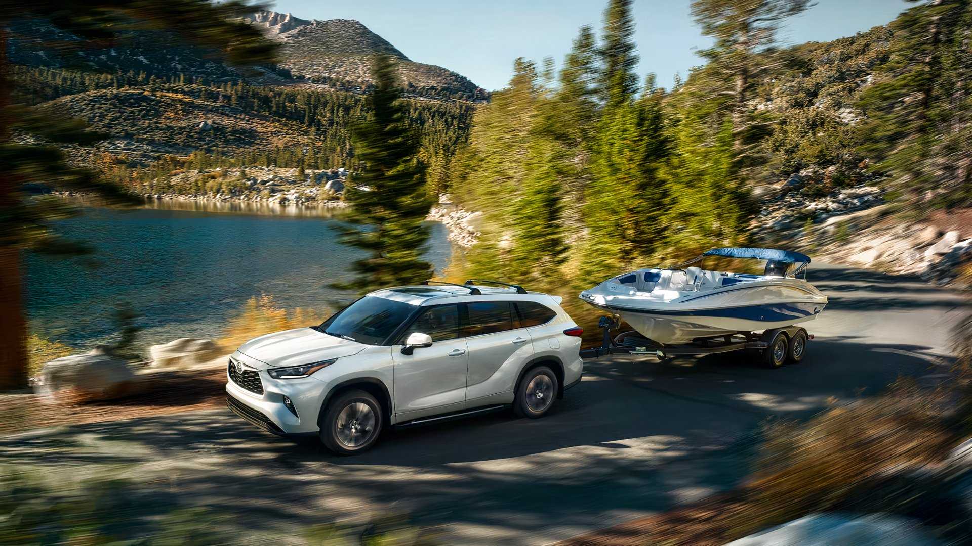 2026 Toyota Highlander Hybrid side shot Pulling A Boat