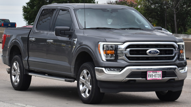 A dark grey 2023 Ford F-150 driving on the street.