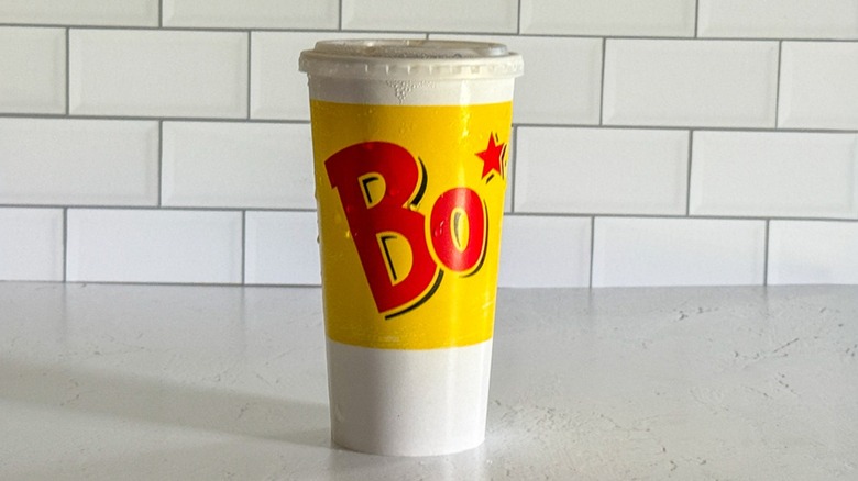A medium Bojangles cup containing sweet tea