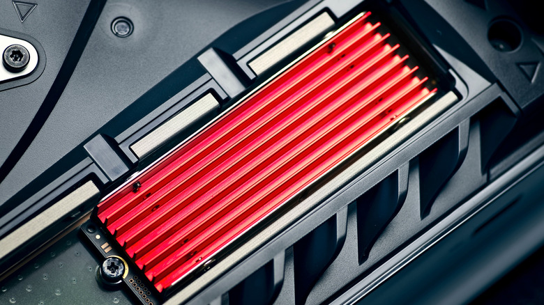 The innards of a PlayStation 5 with an extra SSD inserted in its storage slot