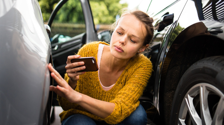 A renter photographing damage on a rental car