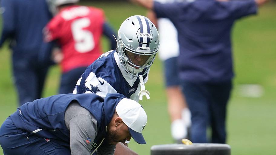 Dallas Cowboys cornerback Caleb Downs (18) is coached through a drill with defensive coordinator Christian Parker.