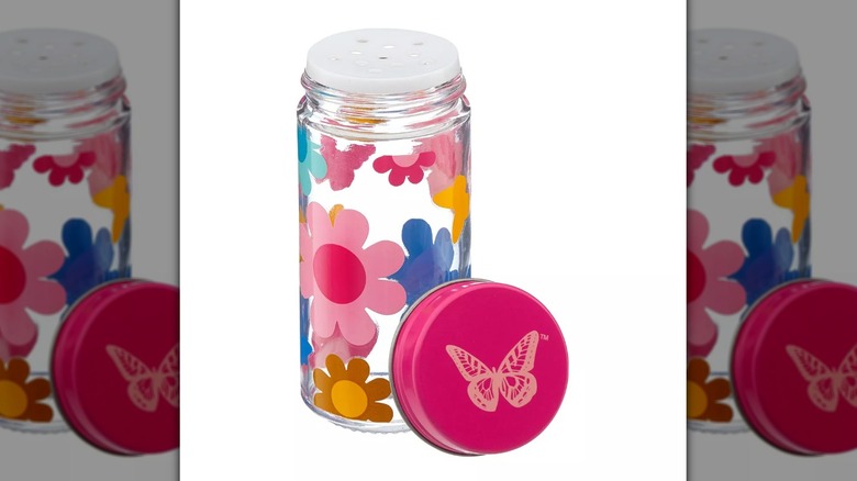 Tall spice canister with pink, yellow, and blue floral decorations and a butterfly on the lid