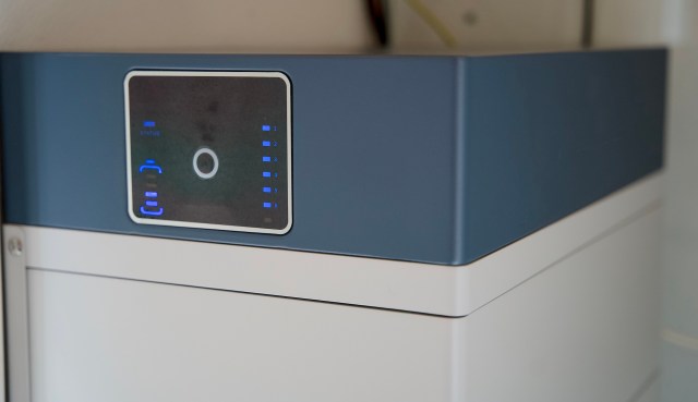 A close-up of a modern electronic device with a digital display and blue indicator lights.