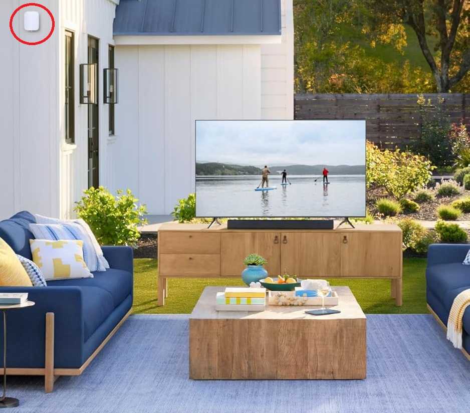 An Eero outdoor mesh node shown next to outdoor garden furniture.