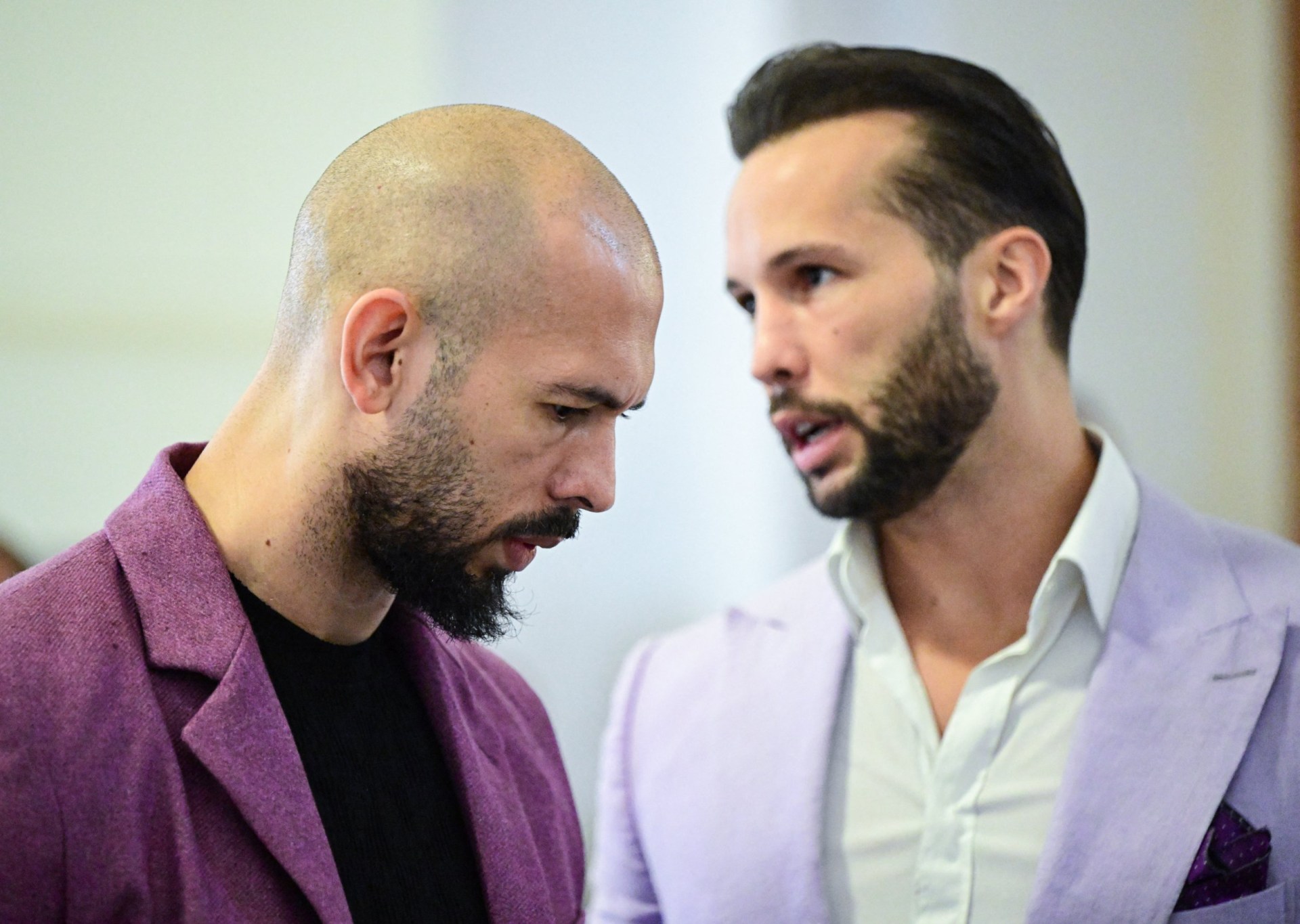 (FILES) Andrew Tate (L) and his brother Tristan Tate are pictured inside The Court of Appeal in Bucharest, Romania, on December 10, 2024. Avowed misogynist and social media influencer Andrew Tate and his brother have been charged with several counts of rape, assault and trafficking, UK prosecutors said on May 28, 2025. The accusations were authorised by the Crown Prosecution Service in January 2024, but have only been revealed now. Andrew Tate faces 10 charges including rape, actual bodily harm, human trafficking and controlling prostitution relating to three women, while his brother, Tristan, has been accused of 11 similar charges against one woman. (Photo by Daniel MIHAILESCU / AFP) (Photo by DANIEL MIHAILESCU/AFP via Getty Images)