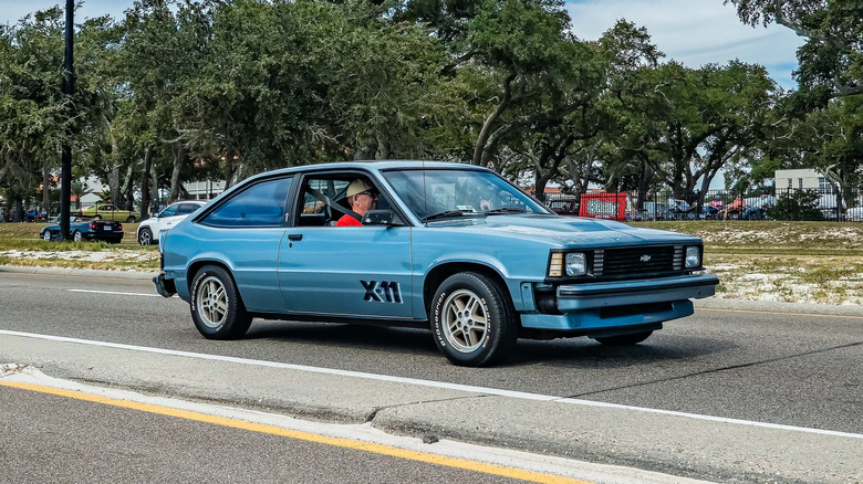 Blue Chevrolet Citation driving on road