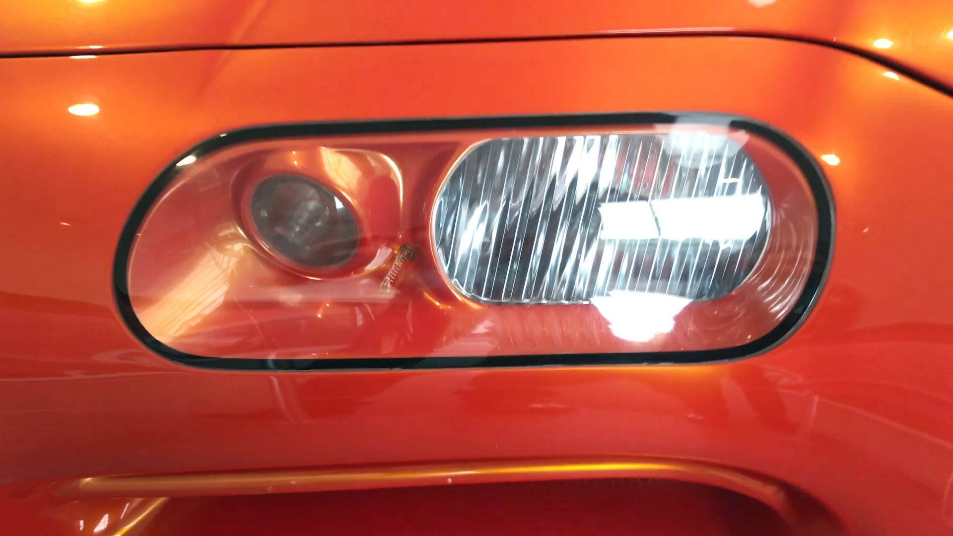 The headlight of an orange Dodge concept car