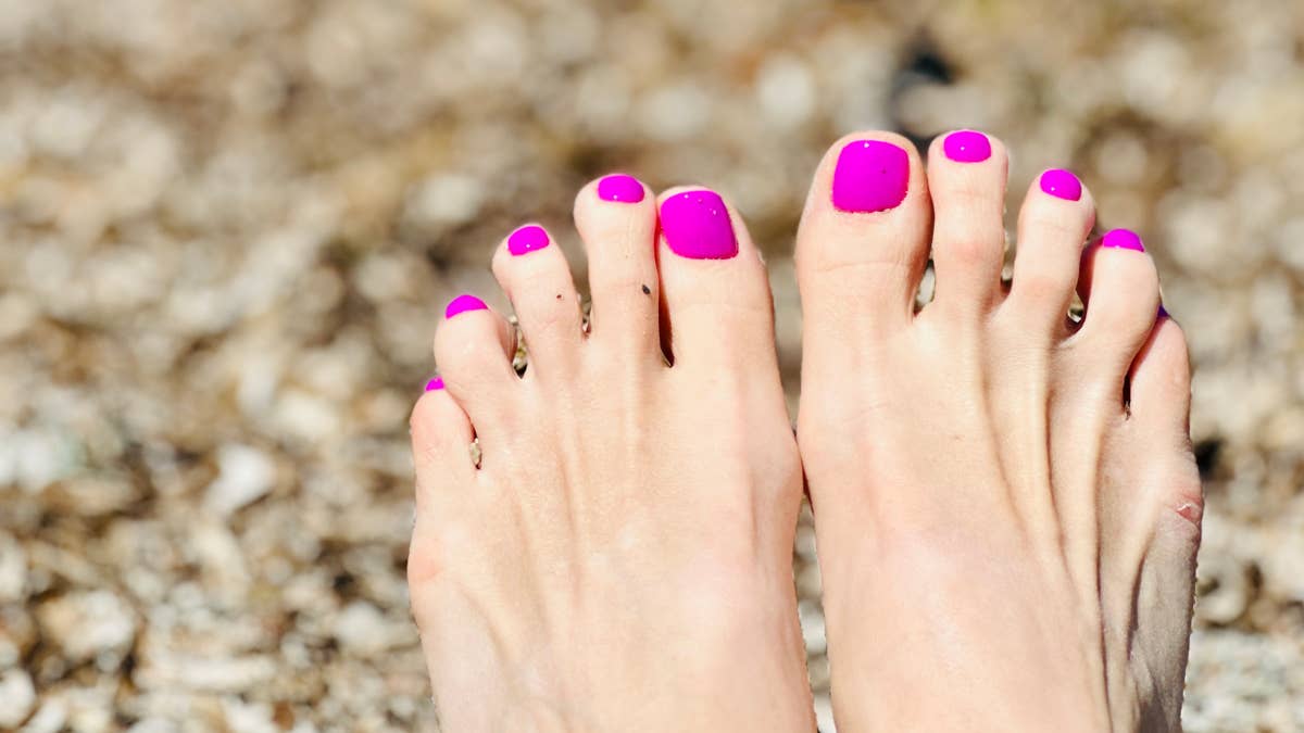 female-feet-with-pedicure-on-the-beach