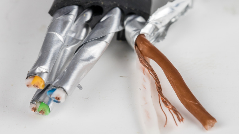 Close up of the exposed end of a Cat8 Ethernet cable showing the heavy shielding round each twisted pair.