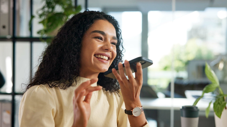 Happy woman speaking into iPhone