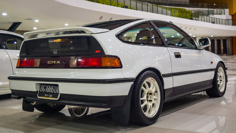 White Honda CR-X, rear three quarter view, parked inside a showroom