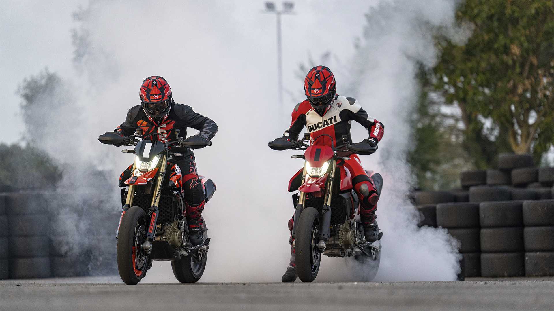 An action shot of two Ducati Hypermotard 698 doing a burnout