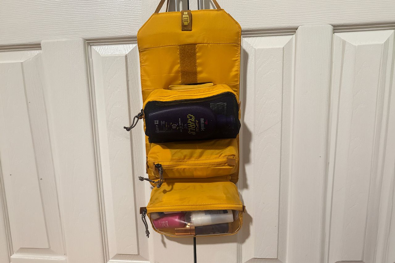 Hanging toiletry bag with items inside on a door