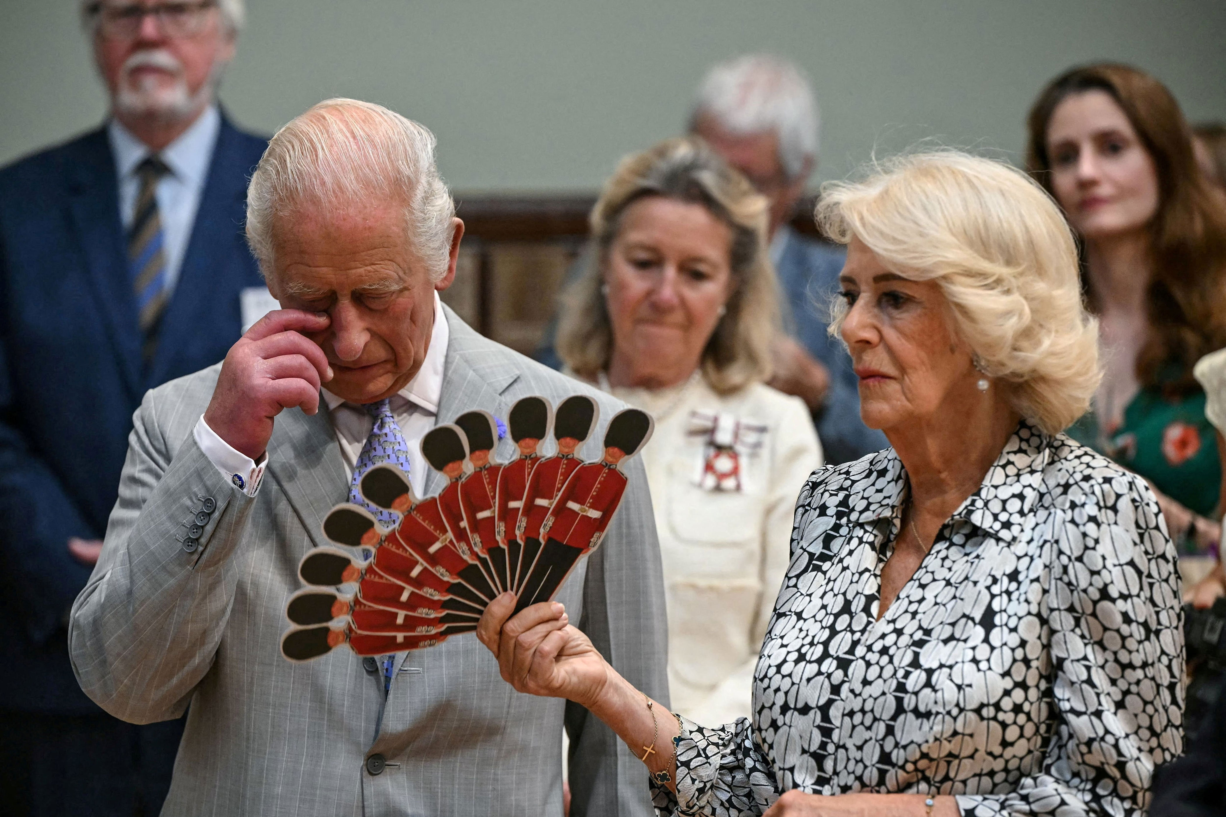 Queen Camilla fans King Charles III in Blandford Forum, England, on July 16, 2026. The couple recently welcomed Harry, Meghan, and their family to a private meeting at Highgrove. / JUSTIN TALLIS / via REUTERS