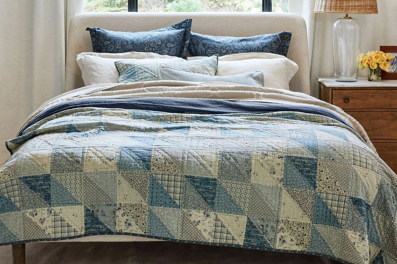 Reversible quilt on a bed with decorative pillows