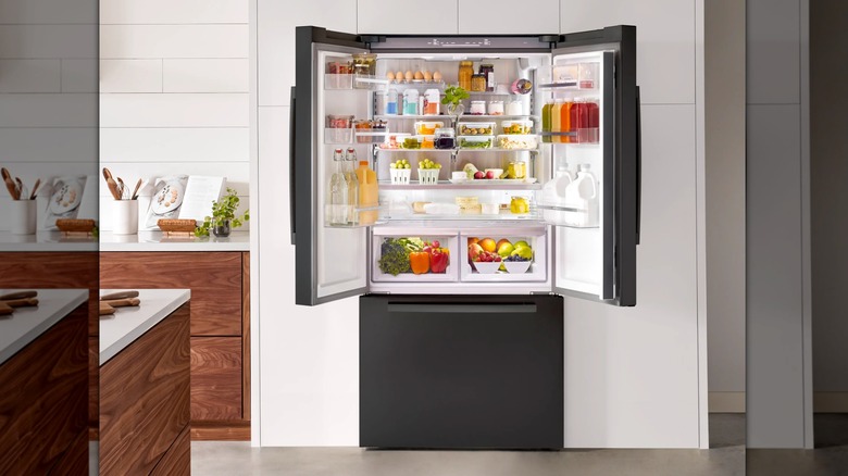 A black fridge is open in a kitchen
