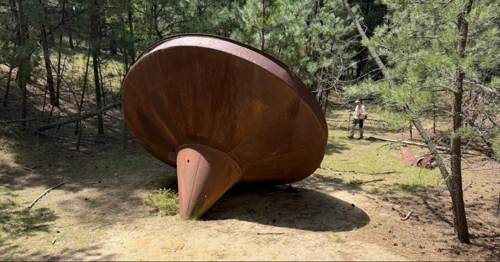 Hiker standing next to a large metal object along the Samelius Trail in South Dakota.