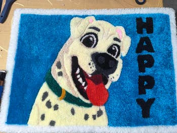 Pictured is a rug with a cartoon dog sticking its tongue out next to the word