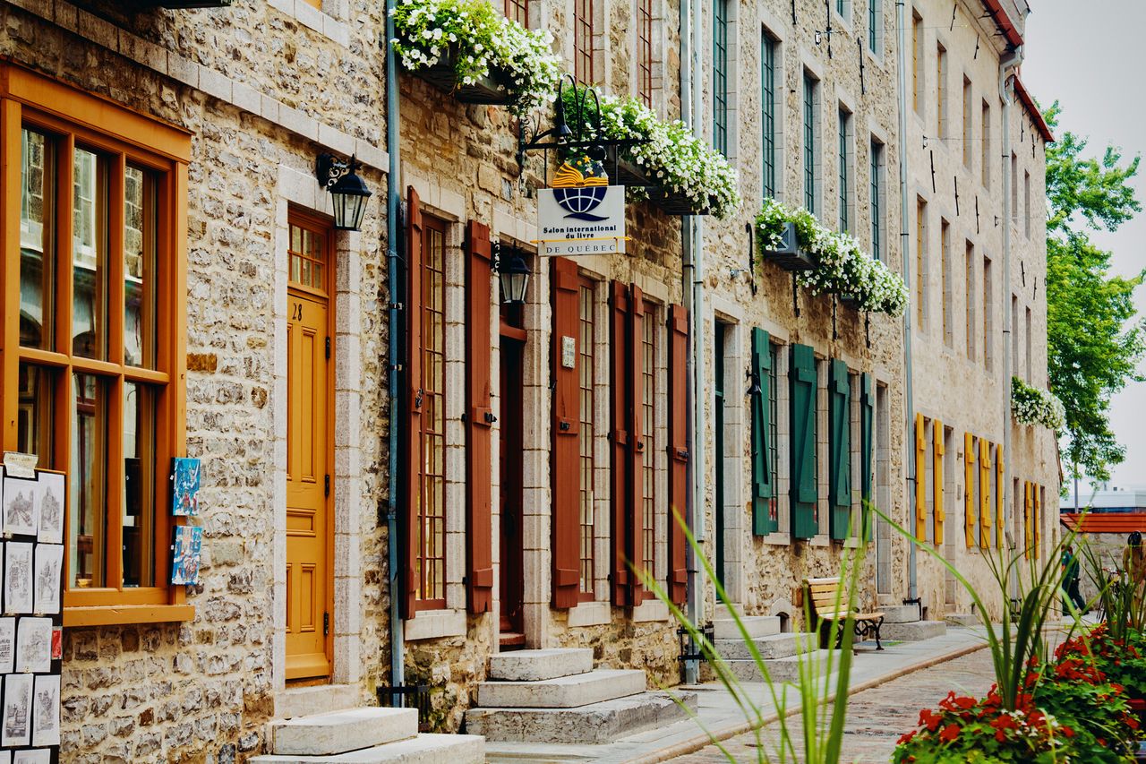 A historic street with stone buildings wooden shutters and flower boxes in Quebec City
