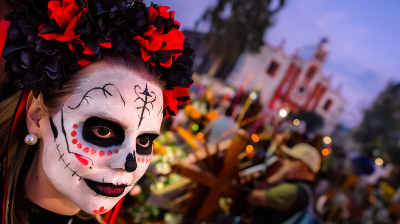 Person dressed as sugar skull during Dia de Los Muertos parade