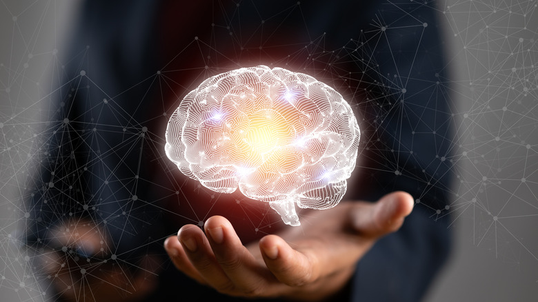 A man holding a floating, glowing human brain in his hand