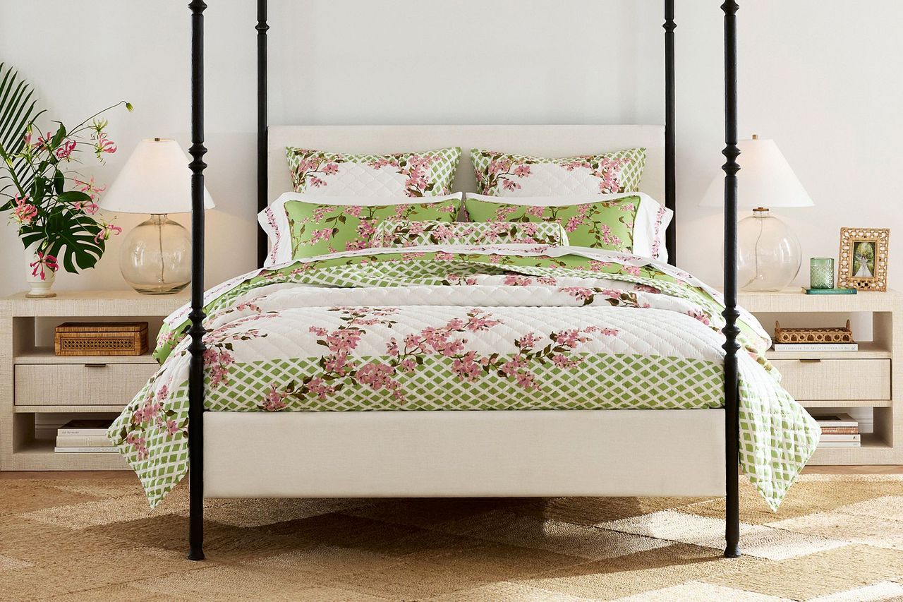 Bed with floralpatterned quilt and coordinated decor in a bedroom setting
