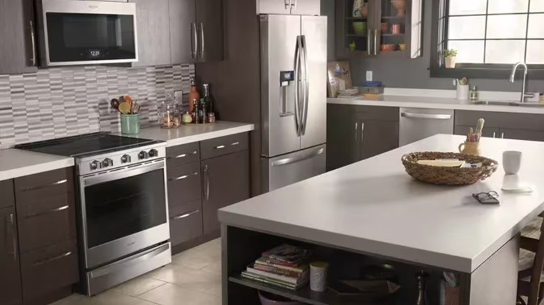 A spacious kitchen with a white island and stainless steel appliances
