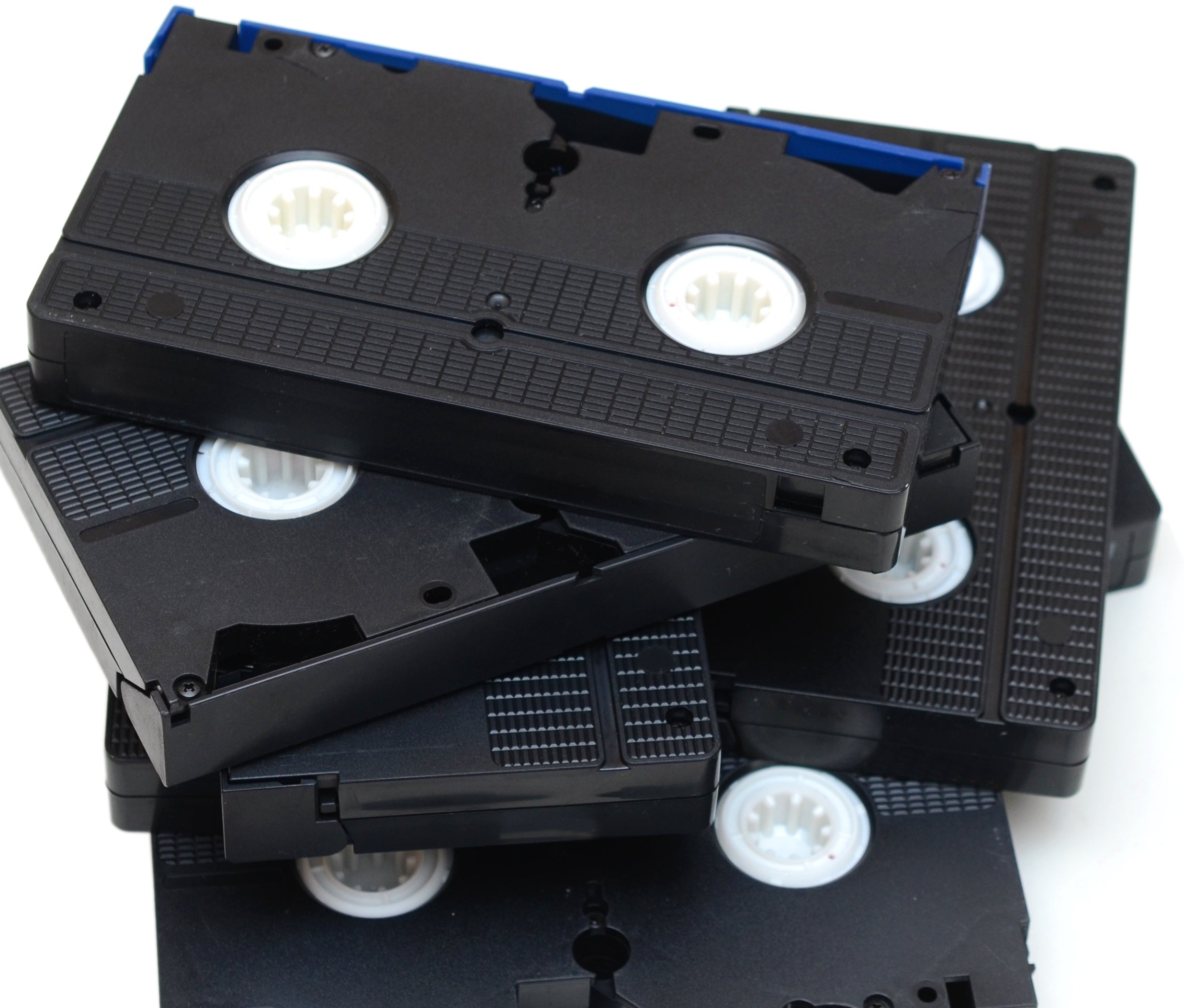 A stack of several VHS tapes, with visible reels, piled at different angles
