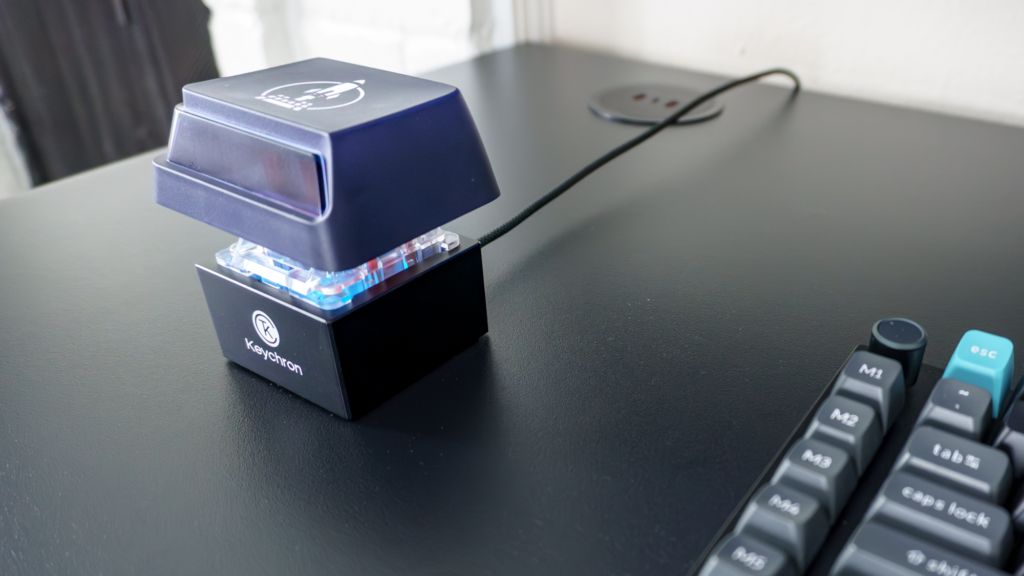 The Keychron Q0 Mini 8K Action Key on the edge of a desk