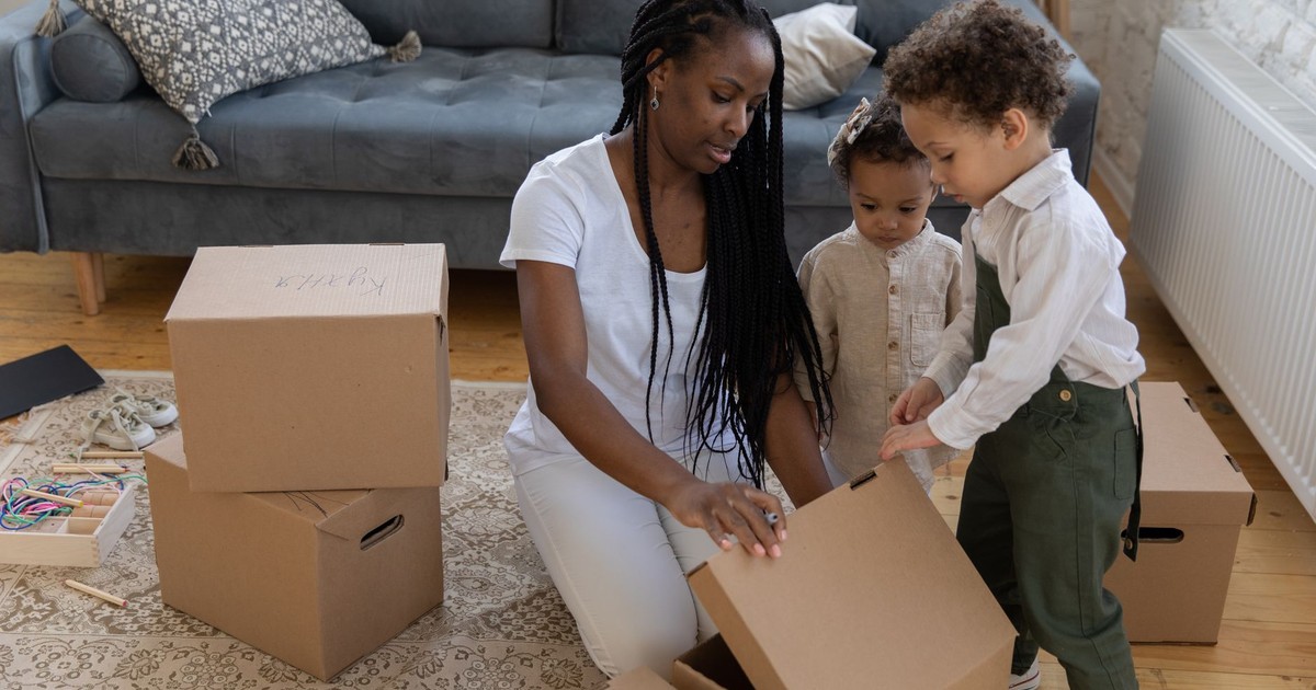 Mother and children unboxing in a cozy living room setting.