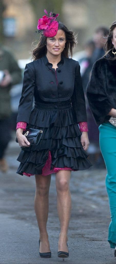Pippa Middleton in a pink lace dress and pink fascinator and black coat