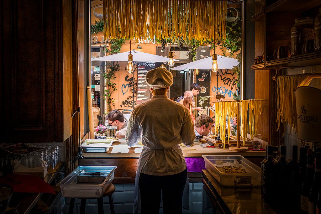 A chef making pasta in a pasta window