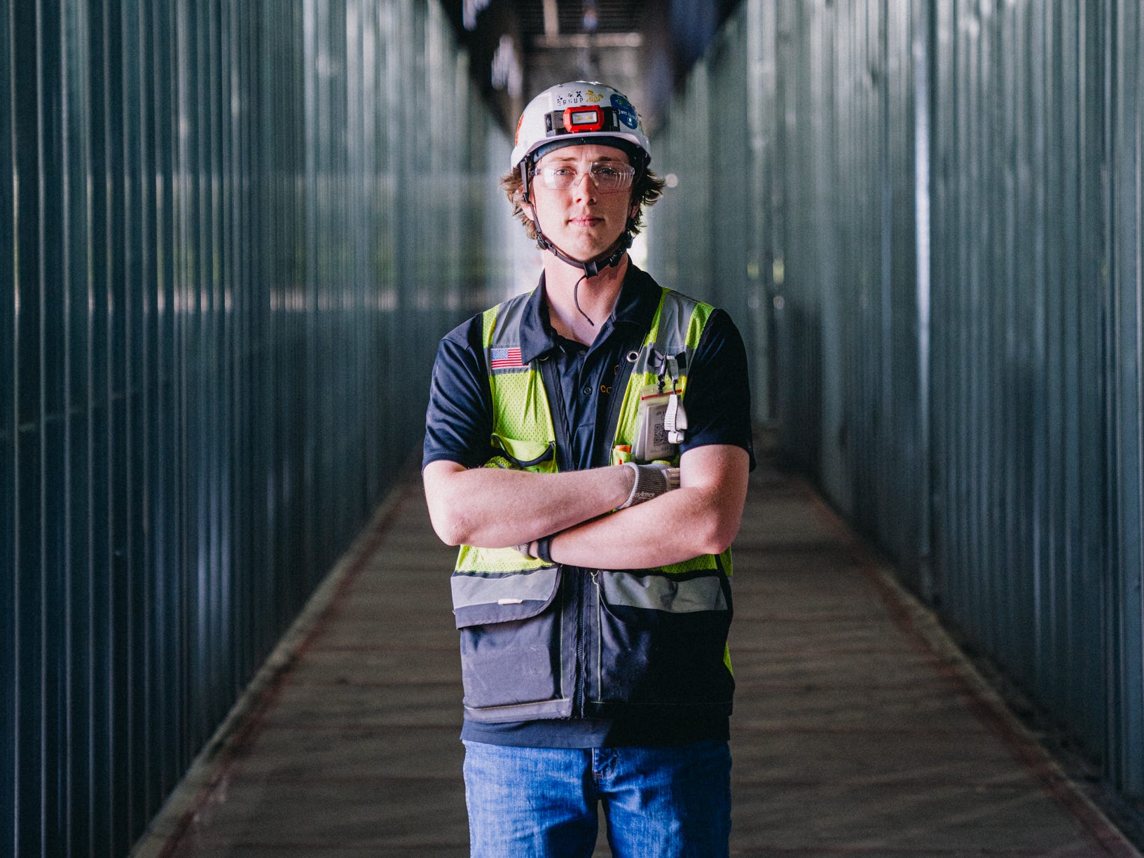 Cody Cole wears a hard hat and yellow work vest