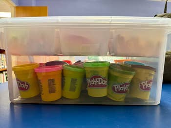 Plastic box filled with various Play-Doh containers