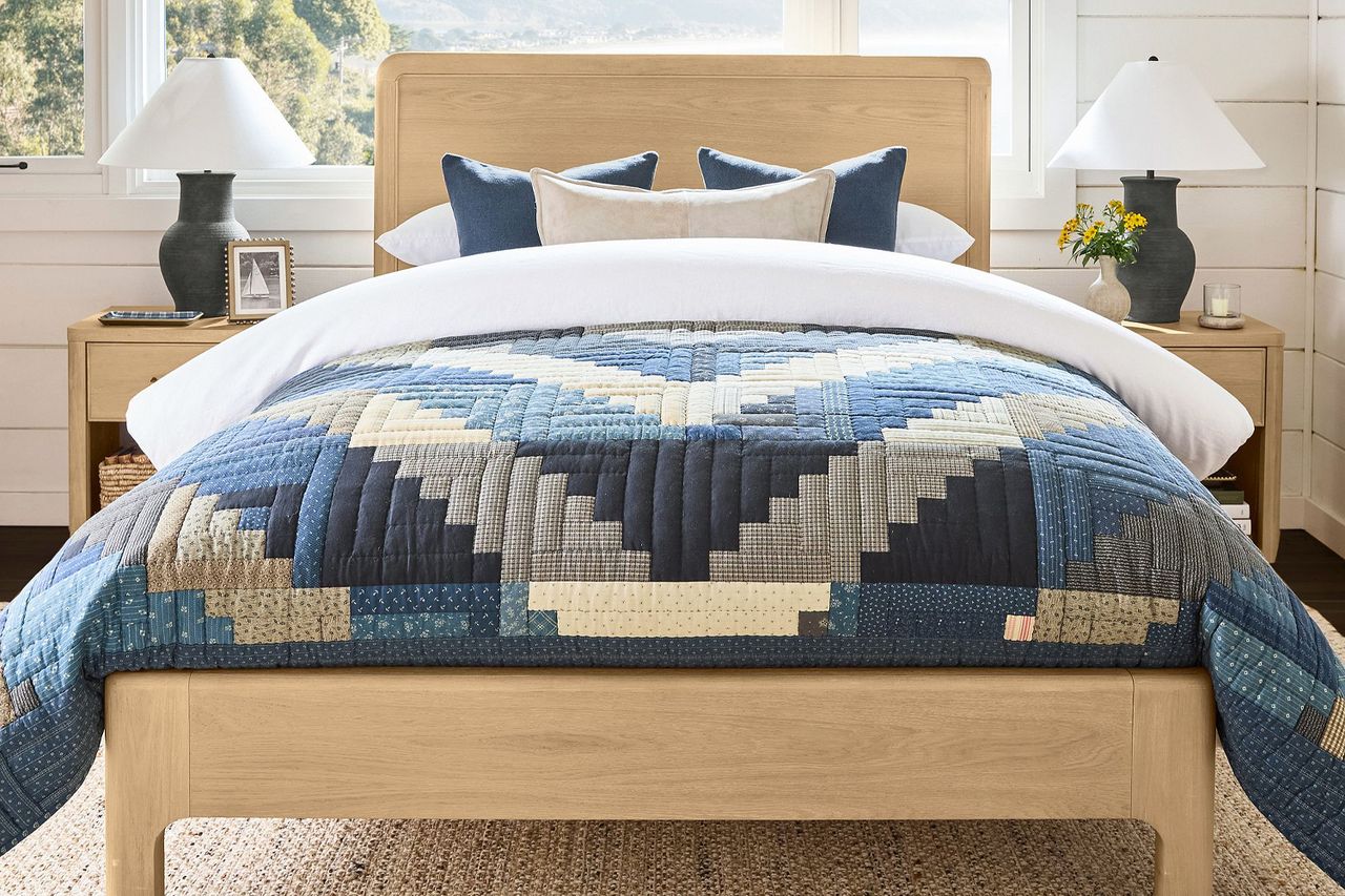 A bedroom scene with a bed featuring a reversible patchwork quilt