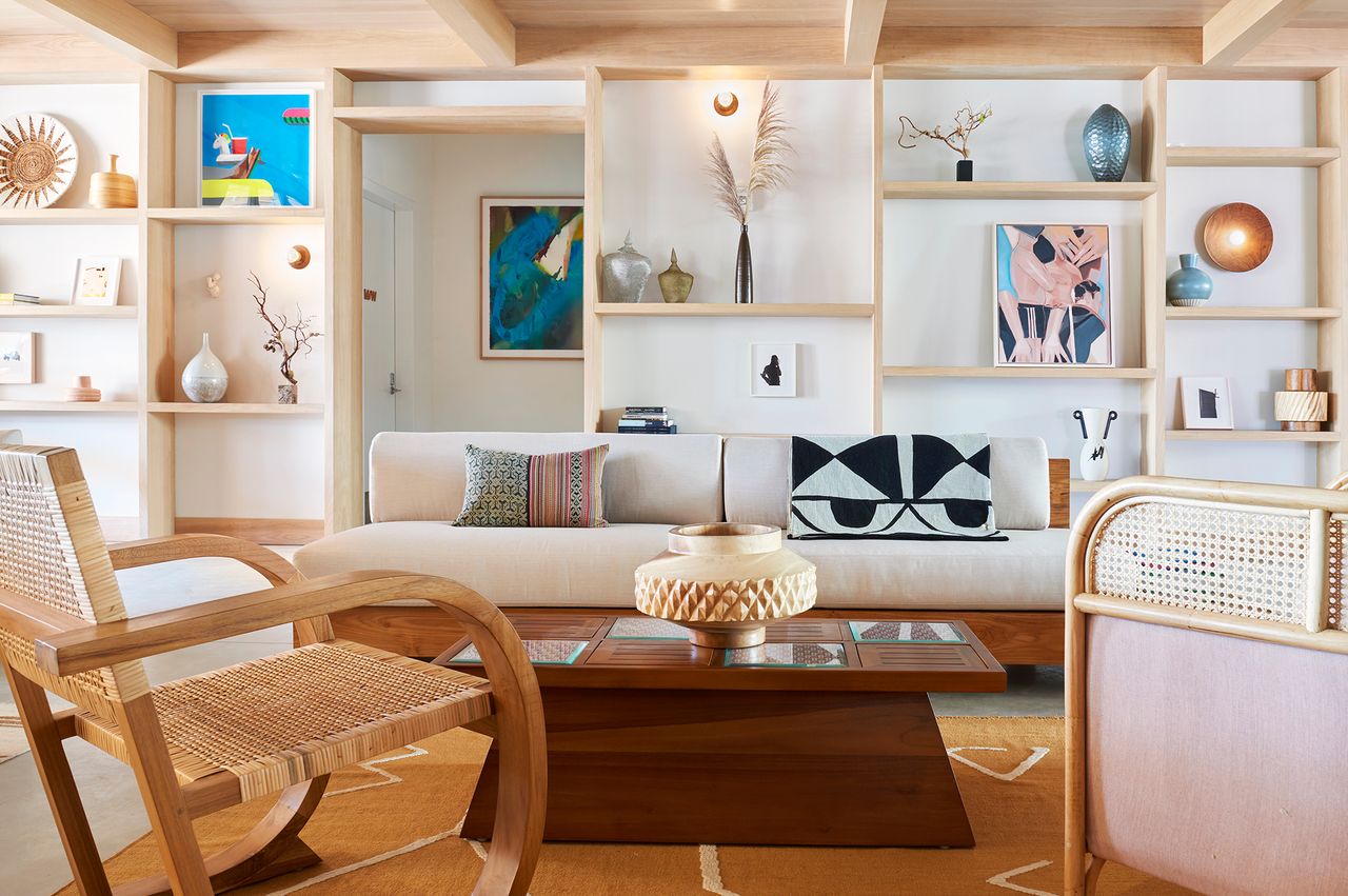 A stylish minimalist and modern lounge area with wooden shelving decorative objects and a sofa at the Rockaway Hotel