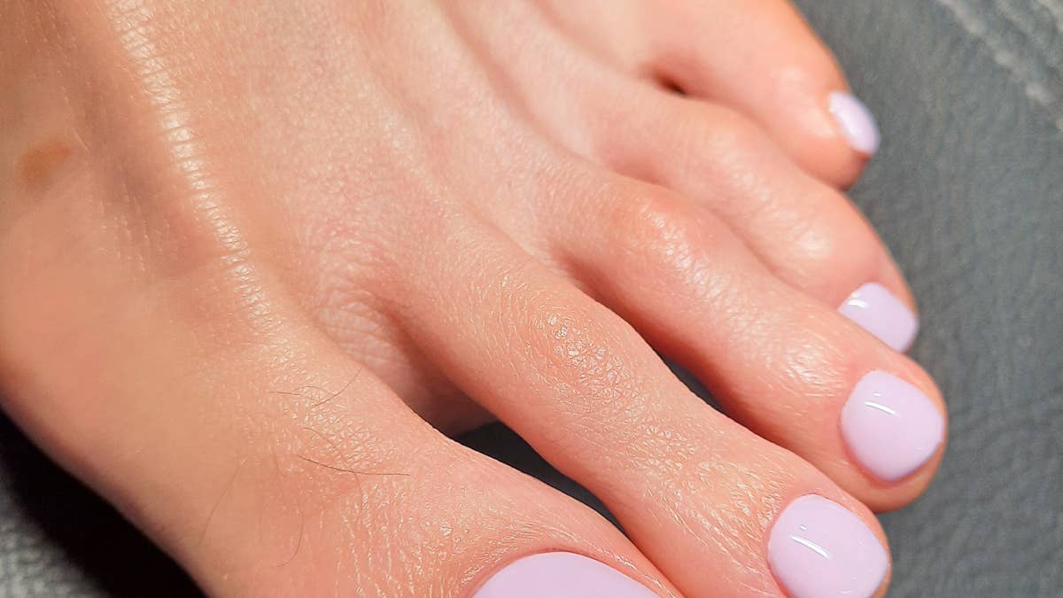 womens-pedicure-with-a-solid-purple-gel-polish-on-the-nails-beautiful-pastel-pedicure-on-violet-colored-feet