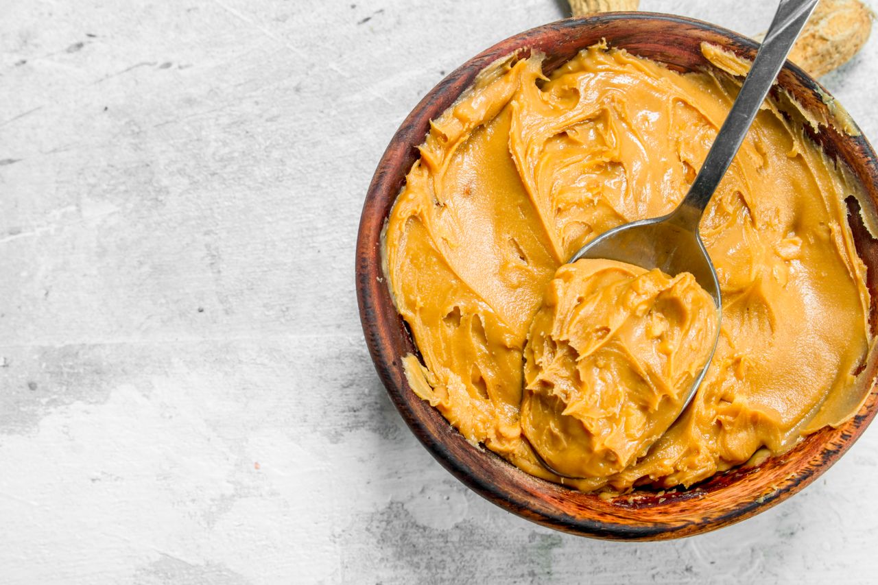 A bowl of peanut butter with a spoon