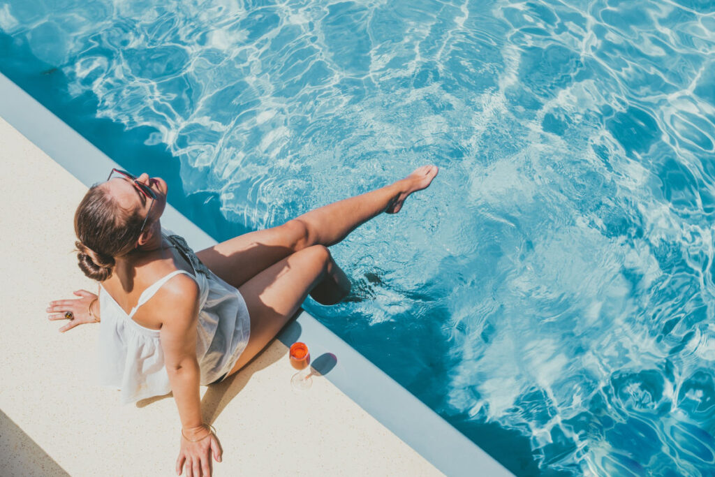 Woman sitting with her feet in the pool