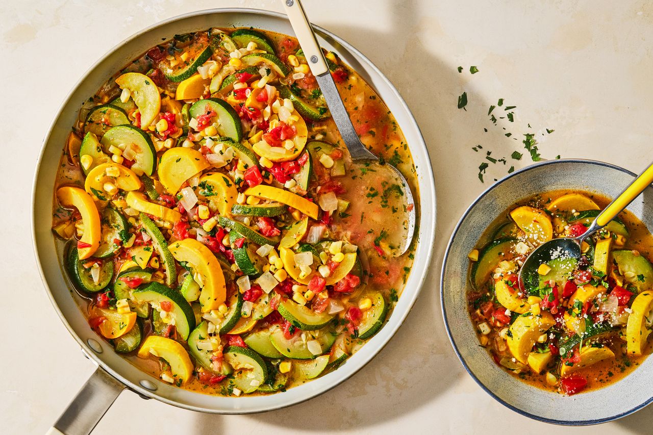 Sauteed zucchini squash and vegetables in a pan with part served in a bowl