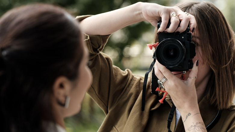 Photographer using a mirrorless camera outdoors.