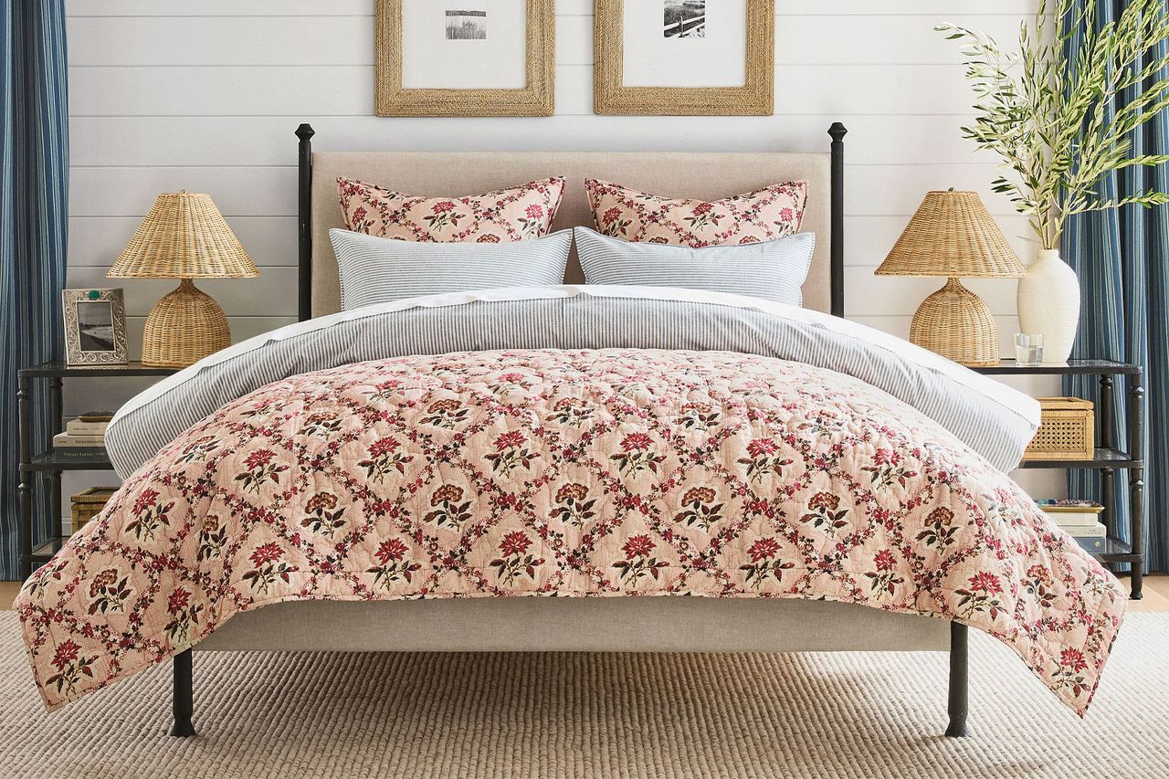 A bed with a floral quilt and coordinated pillows in a welldecorated bedroom