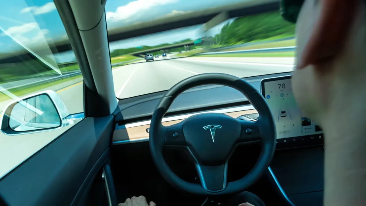 person using the selfdriving function in an all electric tesla
