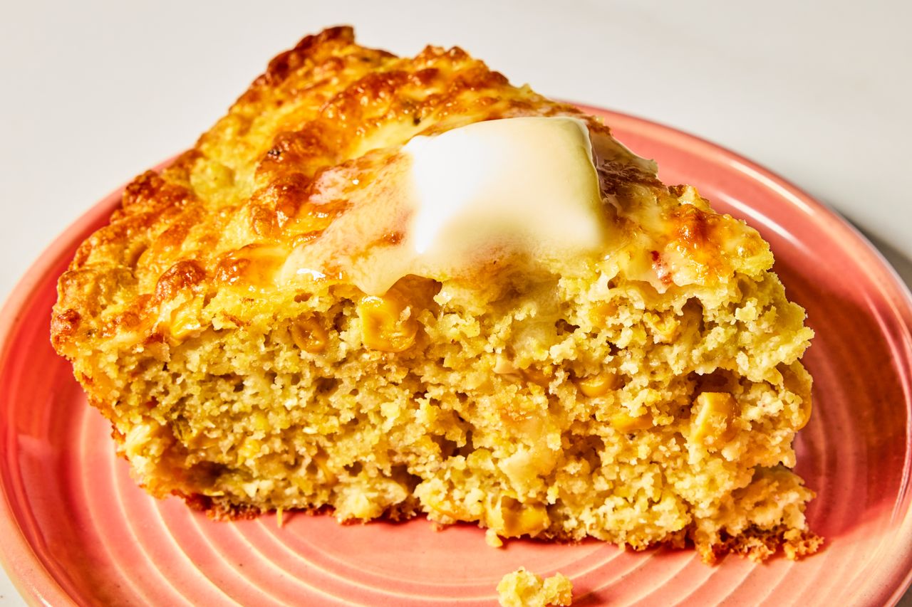 Slice of cornbread on a plate with melted butter on top highlighting its texture and serving presentation